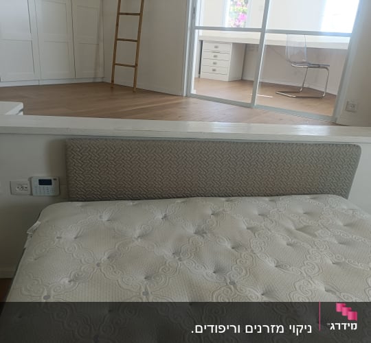 חדר עם מיטה ומזרן, כיסא ושולחן זכוכית